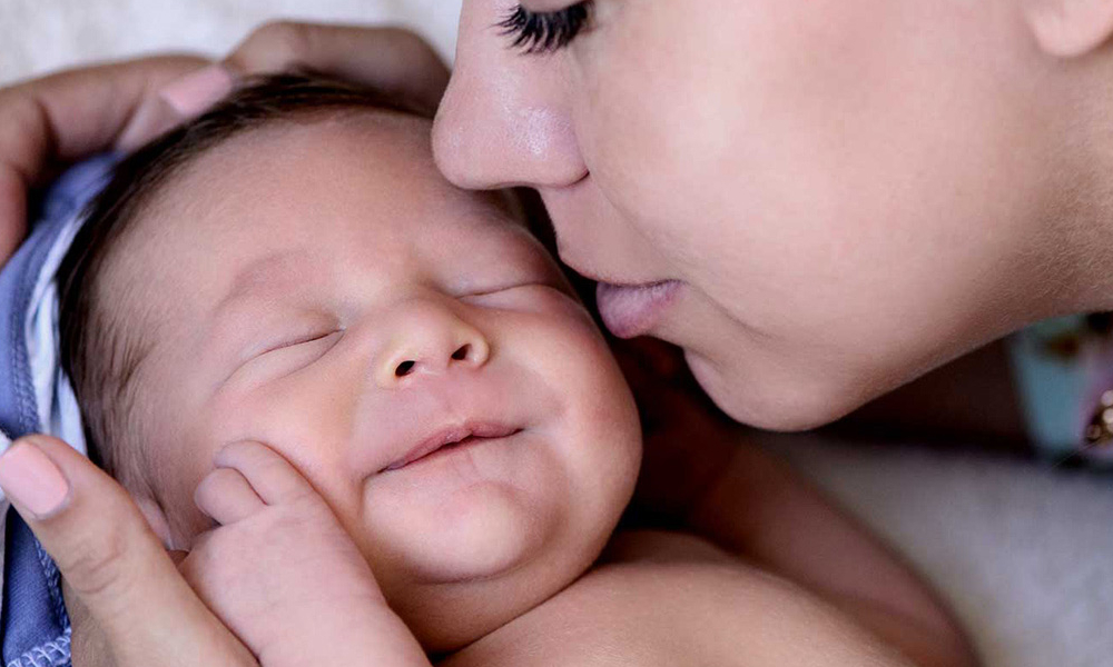 Woman kissing a baby.