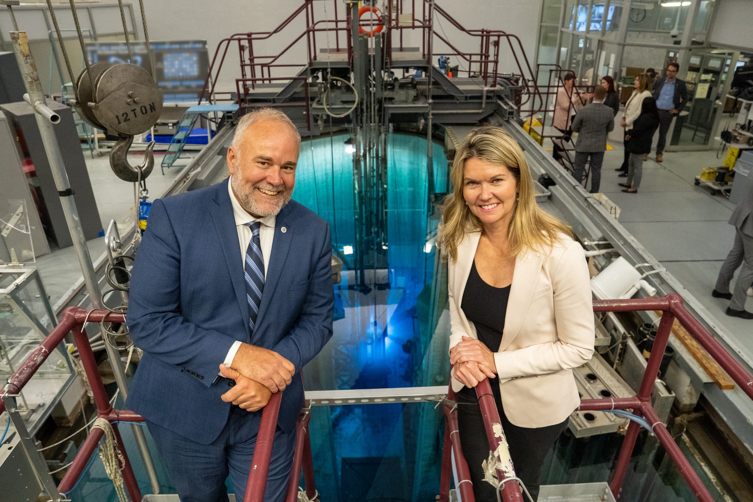 Minister Smith and Minister Dunlop stand in front of McMaster Nuclear Reactor core.
