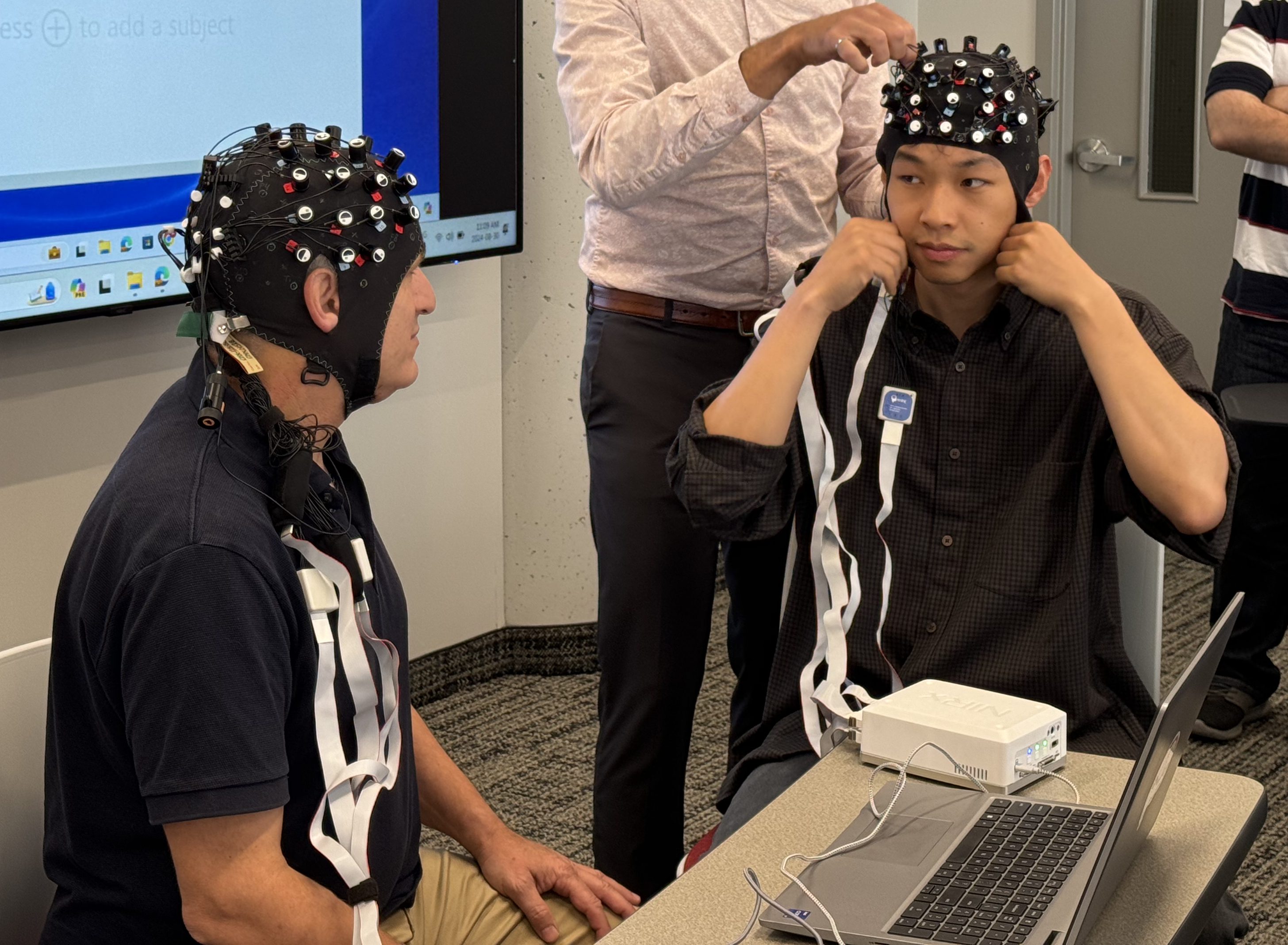 People wearing neuroscience head equipment.