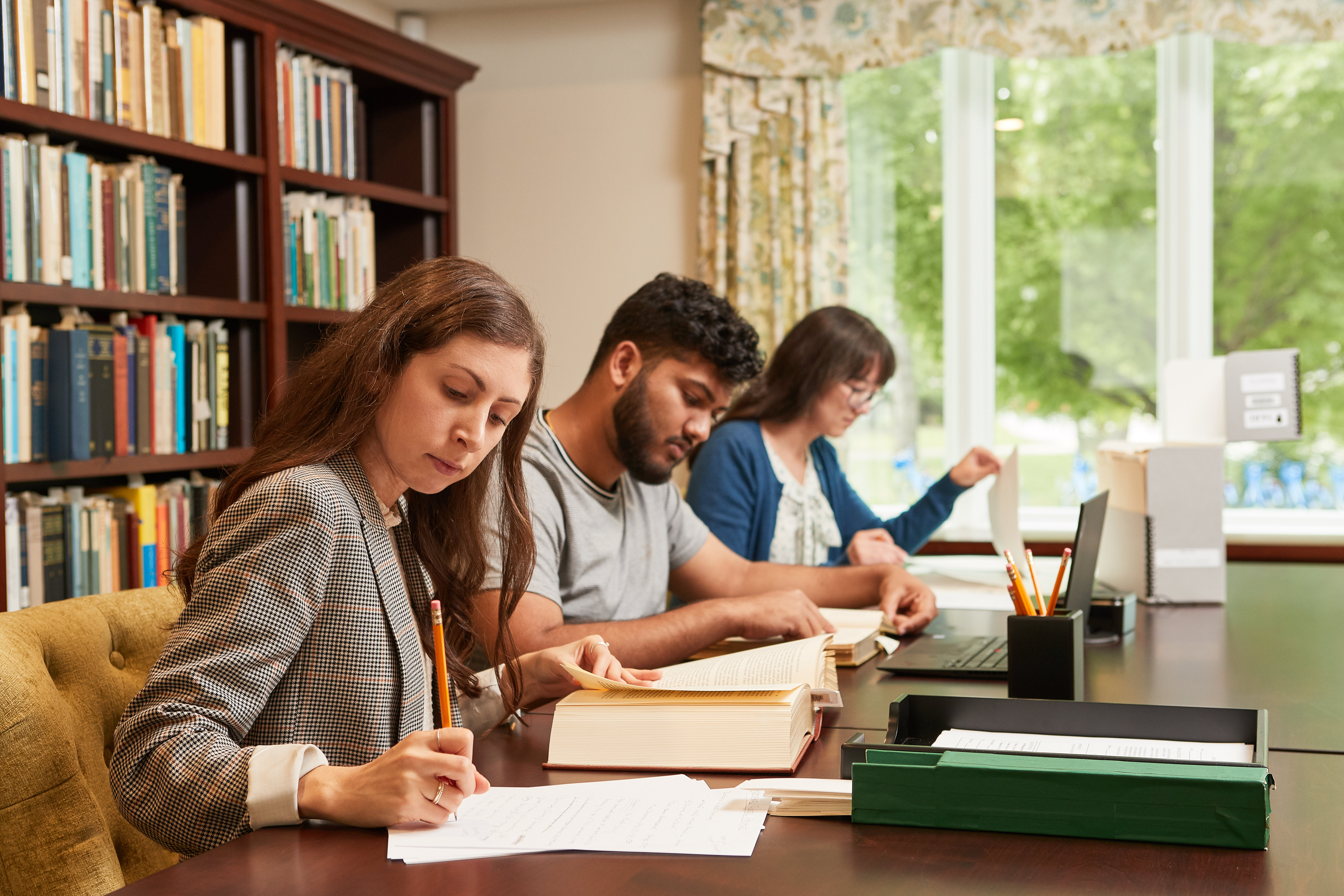 Researchers reading books and writing.